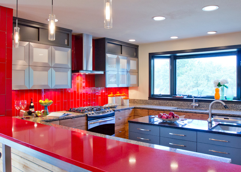 カンザスシティにある高級なコンテンポラリースタイルのおしゃれなキッチン (アンダーカウンターシンク、フラットパネル扉のキャビネット、グレーのキャビネット、クオーツストーンカウンター、赤いキッチンパネル、ガラスタイルのキッチンパネル、シルバーの調理設備) の写真