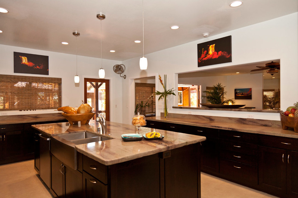 Example of an island style porcelain tile kitchen design in Hawaii with a double-bowl sink, flat-panel cabinets, dark wood cabinets and an island
