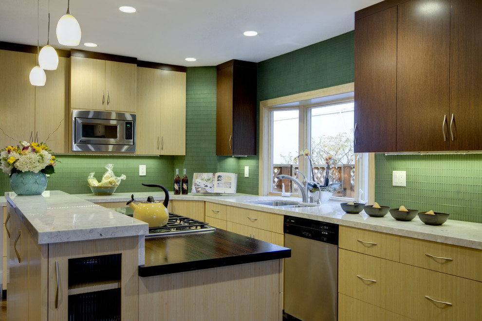 Idéer för ett mellanstort modernt grå kök, med släta luckor, grönt stänkskydd, rostfria vitvaror, en köksö, skåp i mörkt trä, träbänkskiva, stänkskydd i glaskakel, en dubbel diskho och ljust trägolv
