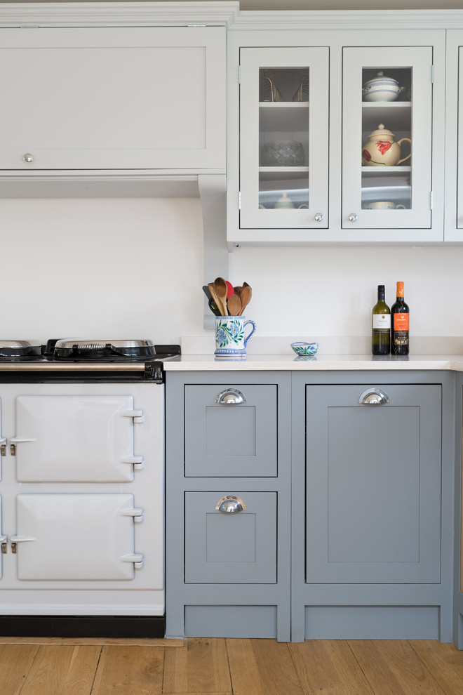 Foto på ett mellanstort lantligt kök och matrum, med skåp i shakerstil, blå skåp, bänkskiva i kvartsit och ljust trägolv
