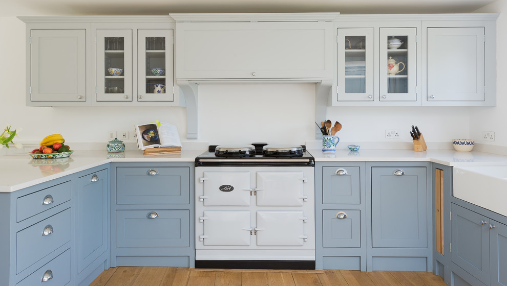 Imagen de cocina comedor campestre de tamaño medio sin isla con armarios estilo shaker, puertas de armario azules, encimera de cuarcita y suelo de madera clara