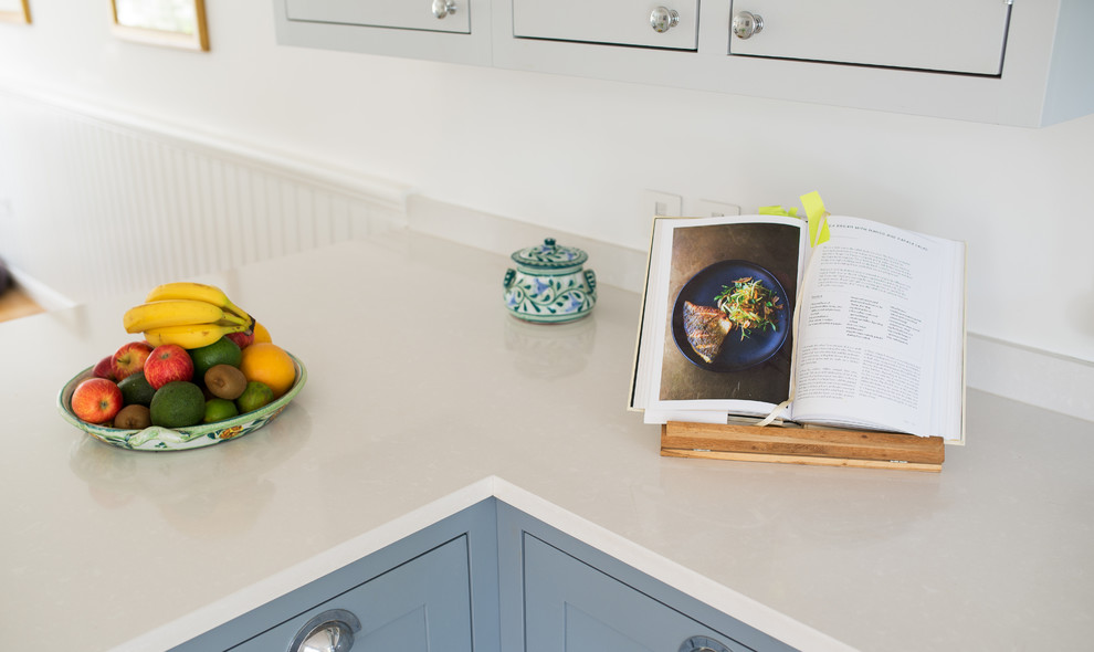 Foto på ett mellanstort lantligt kök och matrum, med skåp i shakerstil, blå skåp, bänkskiva i kvartsit och ljust trägolv