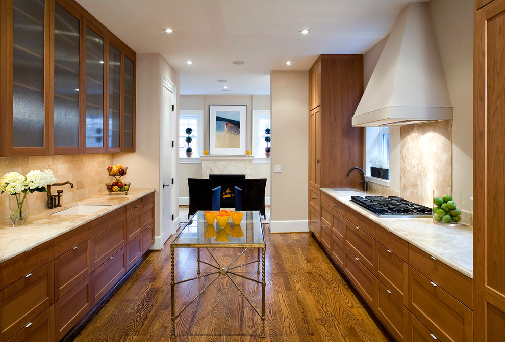 Idée de décoration pour une cuisine parallèle design en bois brun avec un placard à porte vitrée et une crédence beige.