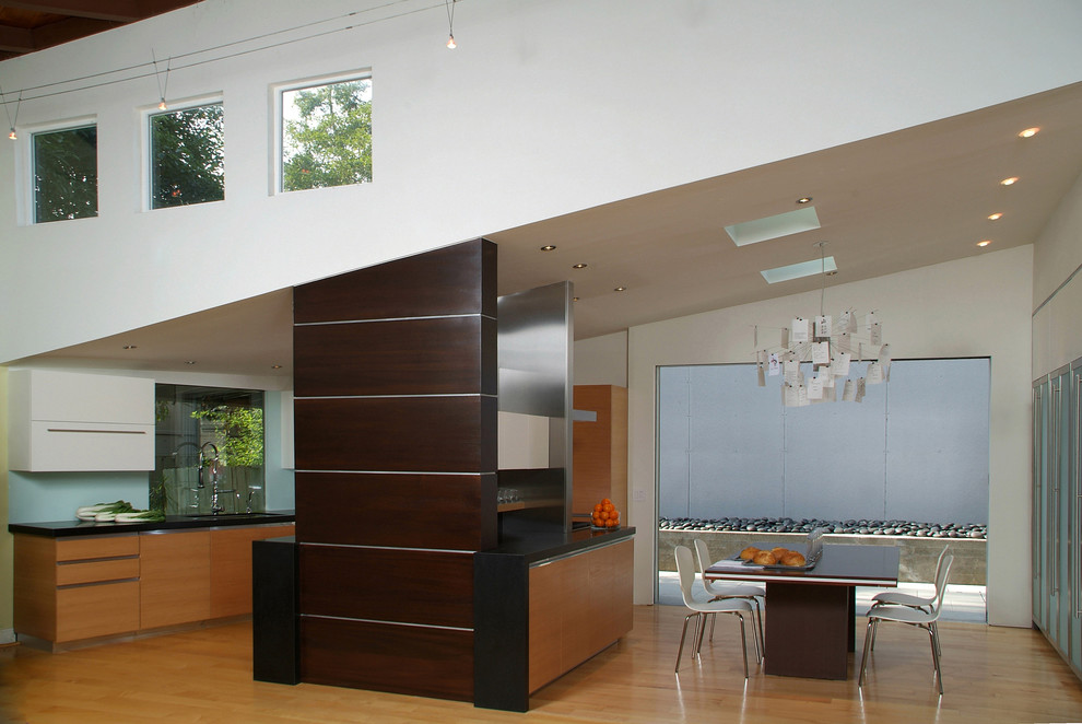 Modelo de cocina comedor minimalista con armarios con paneles lisos y puertas de armario de madera oscura