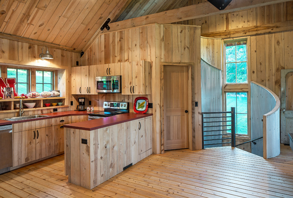 Exemple d'une cuisine montagne en U et bois brun de taille moyenne avec un évier posé, un placard à porte plane, un électroménager en acier inoxydable, un sol en bois brun et une péninsule.