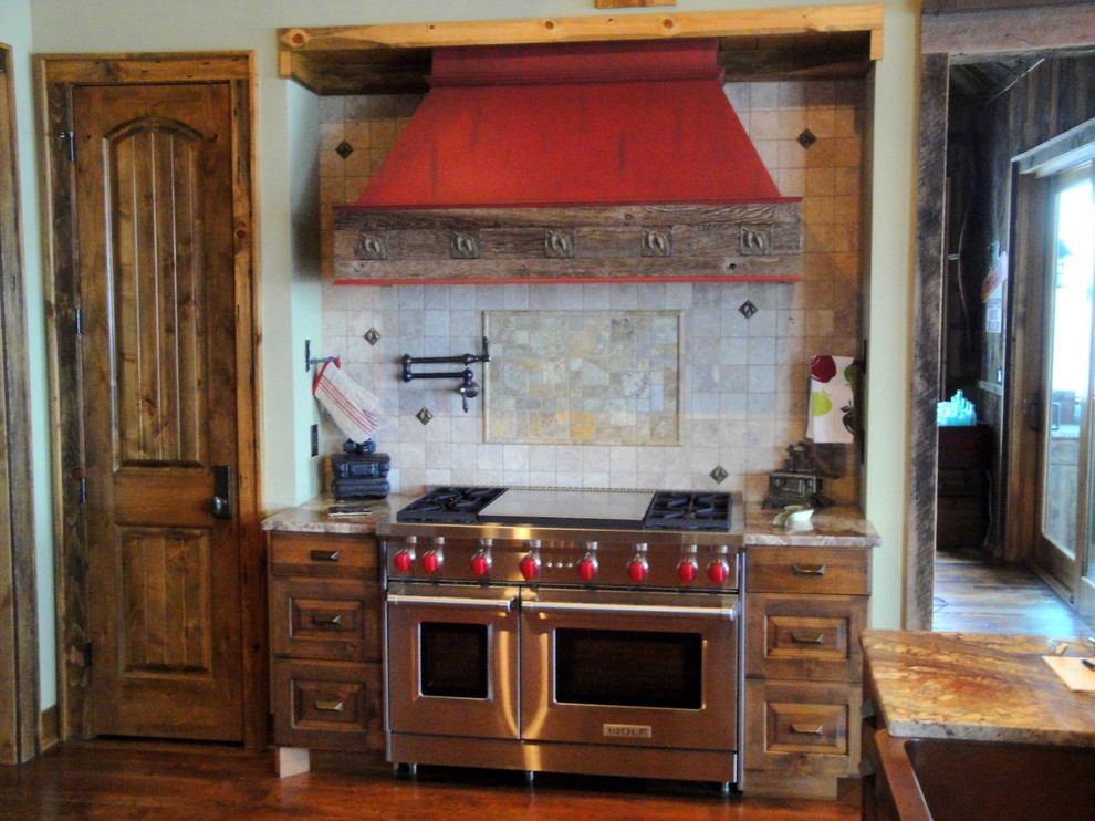 Bild på ett mellanstort rustikt kök, med en dubbel diskho, luckor med upphöjd panel, skåp i mörkt trä, granitbänkskiva, beige stänkskydd, stänkskydd i stenkakel, rostfria vitvaror och mörkt trägolv