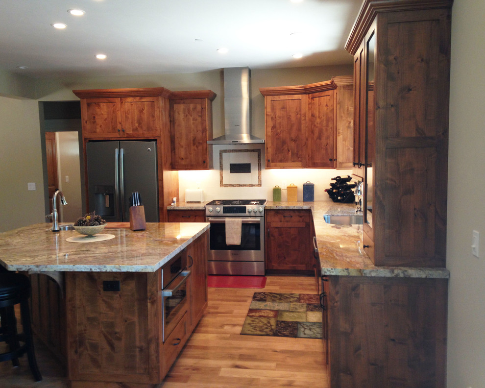 Medium sized rustic l-shaped open plan kitchen in Sacramento with a submerged sink, shaker cabinets, dark wood cabinets, laminate countertops, glass sheet splashback, stainless steel appliances, medium hardwood flooring and an island.