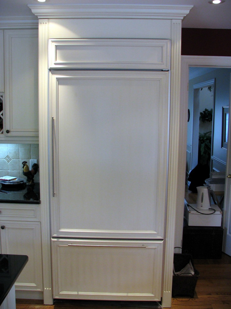 Idéer för ett mellanstort klassiskt kök, med en undermonterad diskho, luckor med infälld panel, vita skåp, granitbänkskiva, beige stänkskydd, stänkskydd i porslinskakel, rostfria vitvaror, mellanmörkt trägolv och en köksö