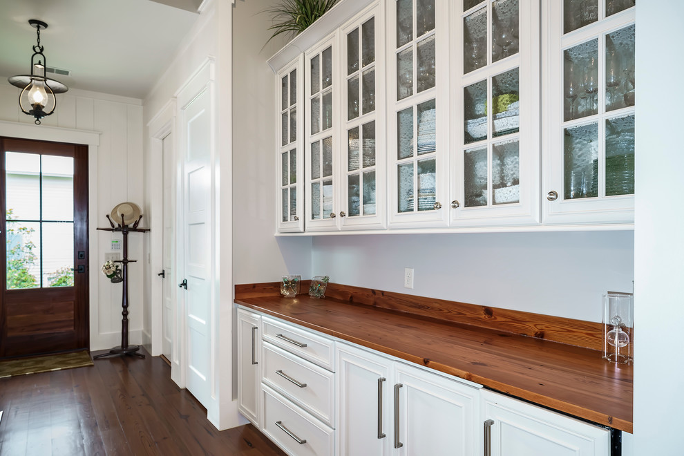 チャールストンにある高級な広いトランジショナルスタイルのおしゃれなアイランドキッチン (白いキャビネット、木材カウンター、無垢フローリング、フラットパネル扉のキャビネット、シルバーの調理設備) の写真