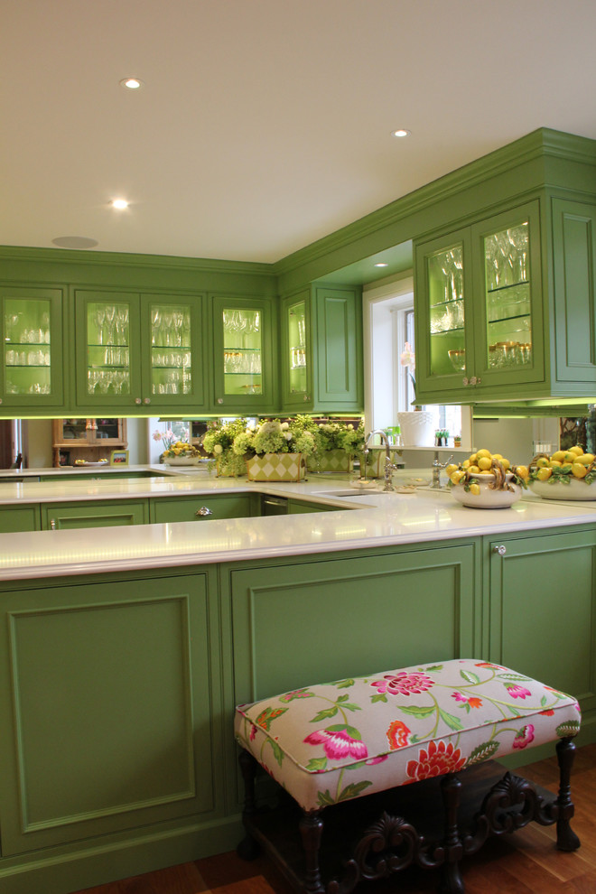 Exempel på ett mellanstort klassiskt kök, med en undermonterad diskho, luckor med glaspanel, gröna skåp, bänkskiva i glas, vitt stänkskydd, spegel som stänkskydd, rostfria vitvaror och mellanmörkt trägolv