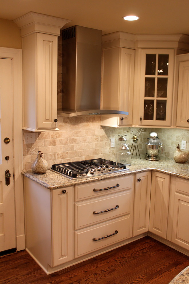 Inredning av ett klassiskt mellanstort kök, med en undermonterad diskho, luckor med upphöjd panel, vita skåp, granitbänkskiva, beige stänkskydd, stänkskydd i keramik, rostfria vitvaror, mellanmörkt trägolv och en köksö