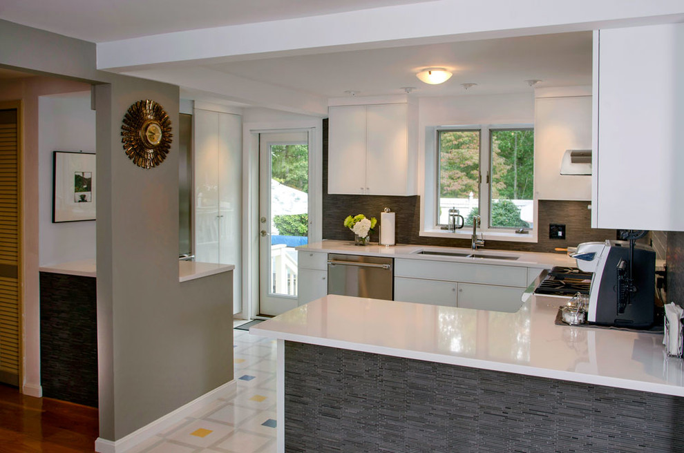 Photo of a contemporary u-shaped kitchen in Providence with a submerged sink, glass-front cabinets, white cabinets, engineered stone countertops, grey splashback, stainless steel appliances and lino flooring.