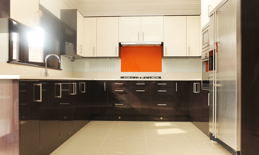 Cette photo montre une cuisine moderne avec des portes de placard marrons, une crédence orange et aucun îlot.