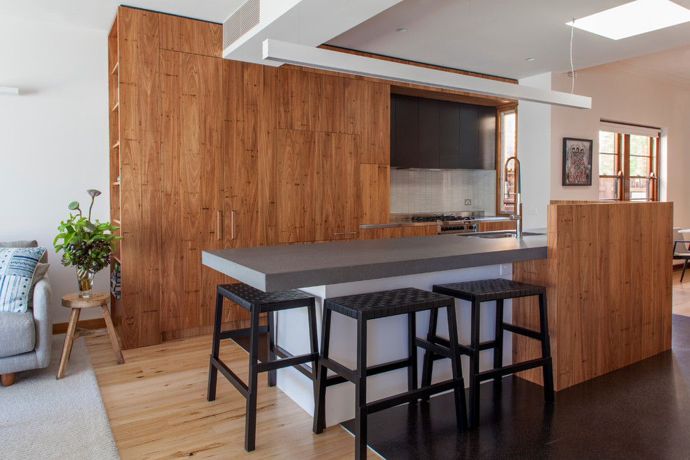 Zweizeilige, Mittelgroße Moderne Wohnküche mit Unterbauwaschbecken, flächenbündigen Schrankfronten, hellbraunen Holzschränken, hellem Holzboden und Kücheninsel in Melbourne