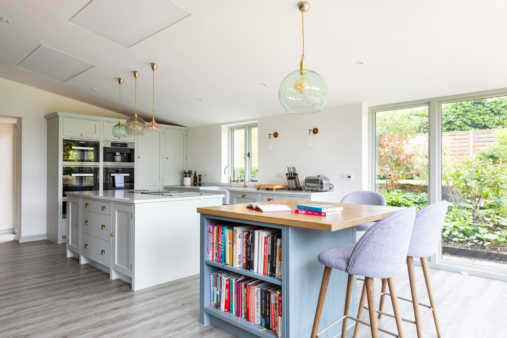 Farmhouse kitchen photo in Oxfordshire with two islands and white countertops