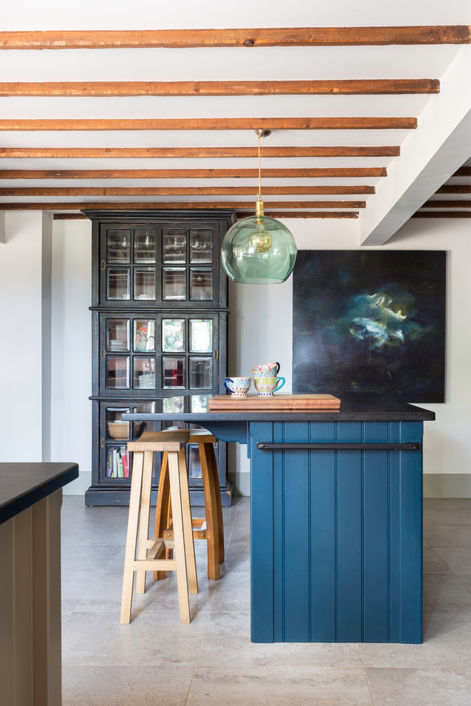 Свежая идея для дизайна: кухня в стиле кантри с синими фасадами, островом, серым полом и черной столешницей - отличное фото интерьера