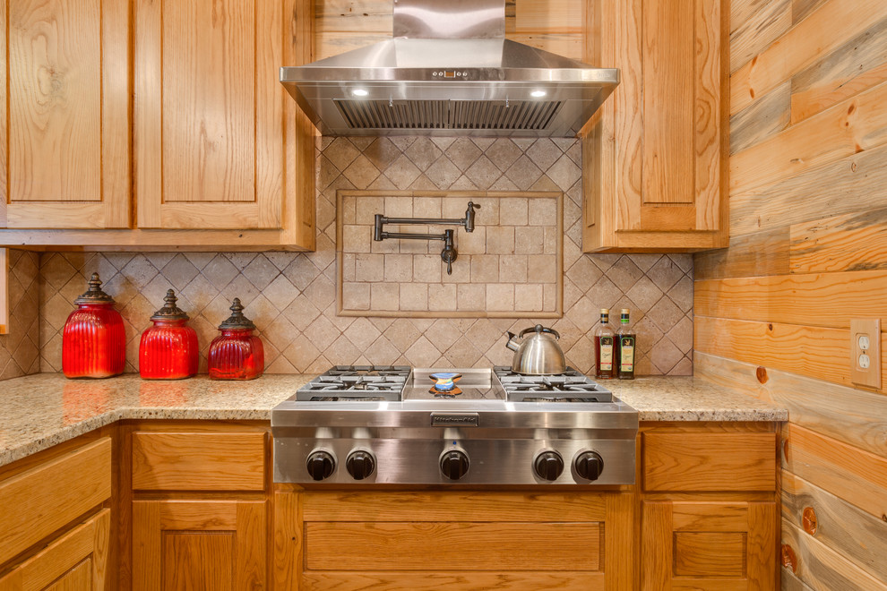 Foto på ett mellanstort amerikanskt kök, med en rustik diskho, luckor med upphöjd panel, skåp i ljust trä, granitbänkskiva, beige stänkskydd, stänkskydd i travertin, rostfria vitvaror, betonggolv och brunt golv