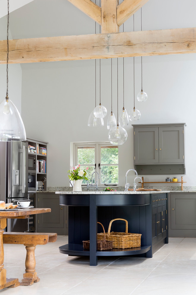 Immagine di una cucina country con ante in stile shaker, ante grigie, elettrodomestici in acciaio inossidabile, penisola e pavimento grigio
