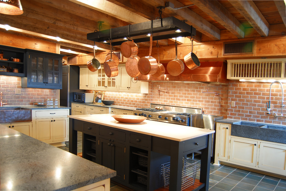 Inredning av ett rustikt stort kök, med en rustik diskho, skåp i shakerstil, vita skåp, bänkskiva i koppar, rött stänkskydd, stänkskydd i tegel, färgglada vitvaror, skiffergolv och en köksö