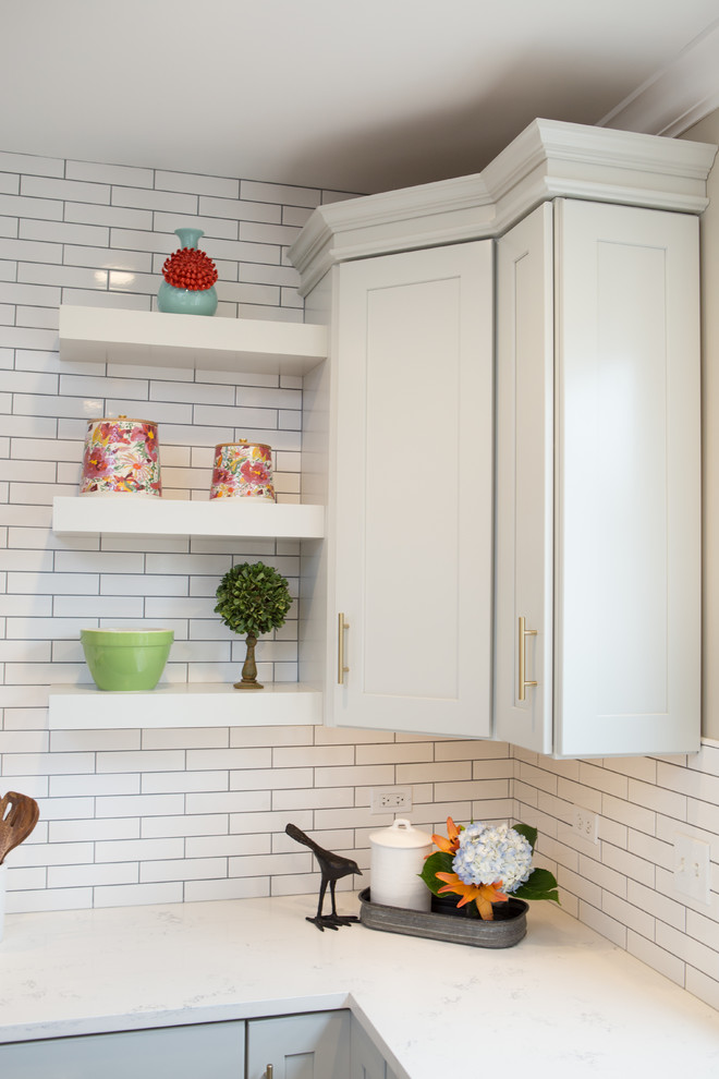 Exempel på ett mellanstort lantligt vit vitt u-kök, med en rustik diskho, släta luckor, vita skåp, bänkskiva i kvarts, vitt stänkskydd, stänkskydd i tunnelbanekakel, rostfria vitvaror, mellanmörkt trägolv, en köksö och brunt golv