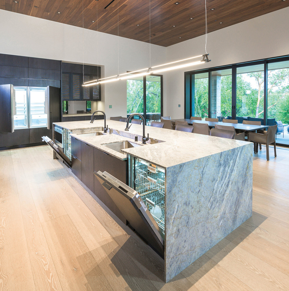 This is an example of a large modern galley kitchen/diner in San Francisco with flat-panel cabinets, dark wood cabinets, quartz worktops, grey splashback, an island and brown worktops.