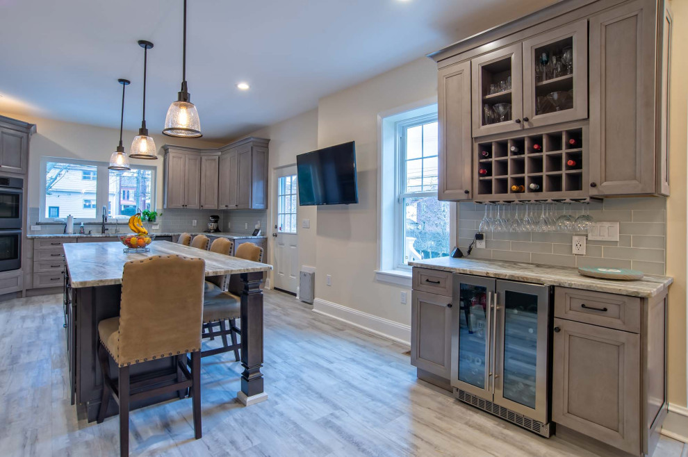Eat-in kitchen - large l-shaped medium tone wood floor and multicolored floor eat-in kitchen idea in Philadelphia with an undermount sink, shaker cabinets, green backsplash, glass tile backsplash, stainless steel appliances, an island and multicolored countertops