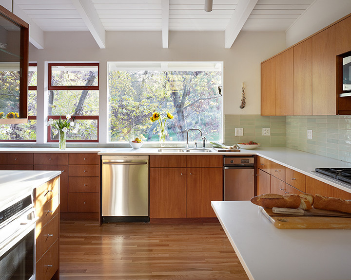 This is an example of a small retro l-shaped kitchen in Kansas City with flat-panel cabinets, medium wood cabinets, green splashback, ceramic splashback and medium hardwood flooring.
