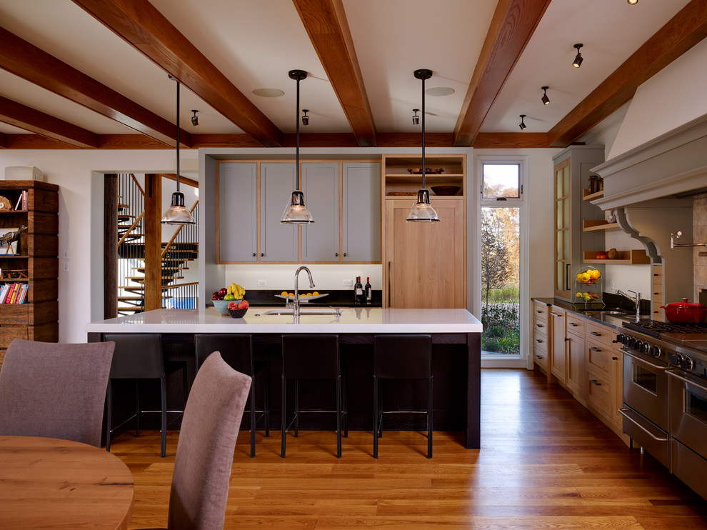 Modern inredning av ett kök och matrum, med integrerade vitvaror, luckor med infälld panel och grå skåp