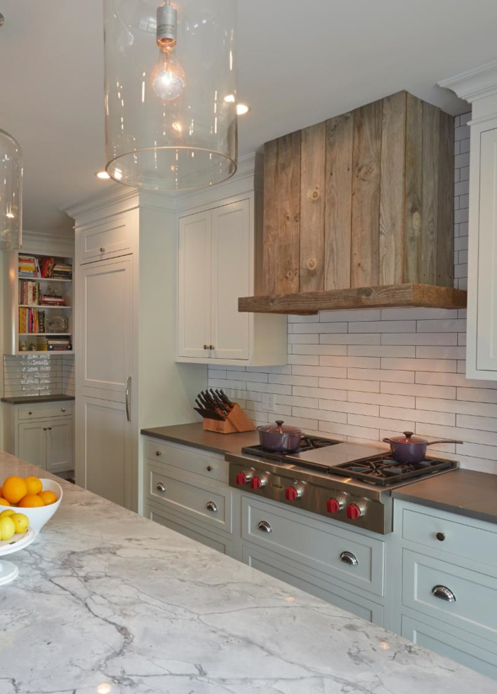 Photo of a medium sized farmhouse kitchen/diner in Chicago with a built-in sink, recessed-panel cabinets, white cabinets, marble worktops, white splashback, ceramic splashback, stainless steel appliances, porcelain flooring and brown floors.
