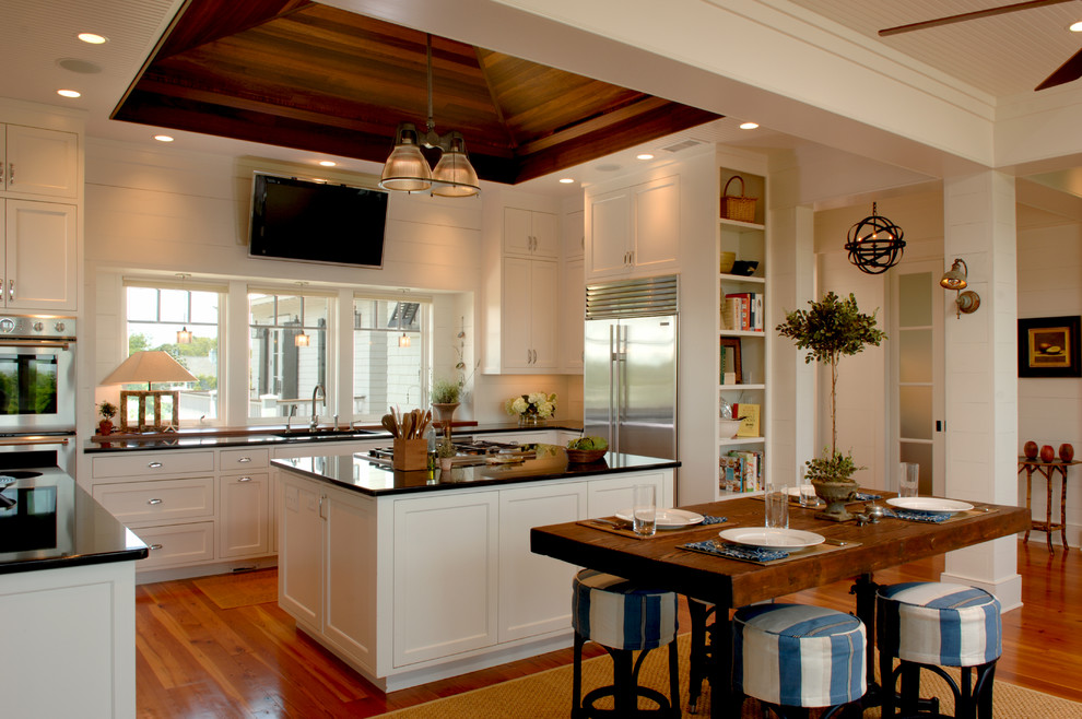 Immagine di una cucina tropicale con lavello sottopiano, ante in stile shaker, ante bianche e elettrodomestici in acciaio inossidabile