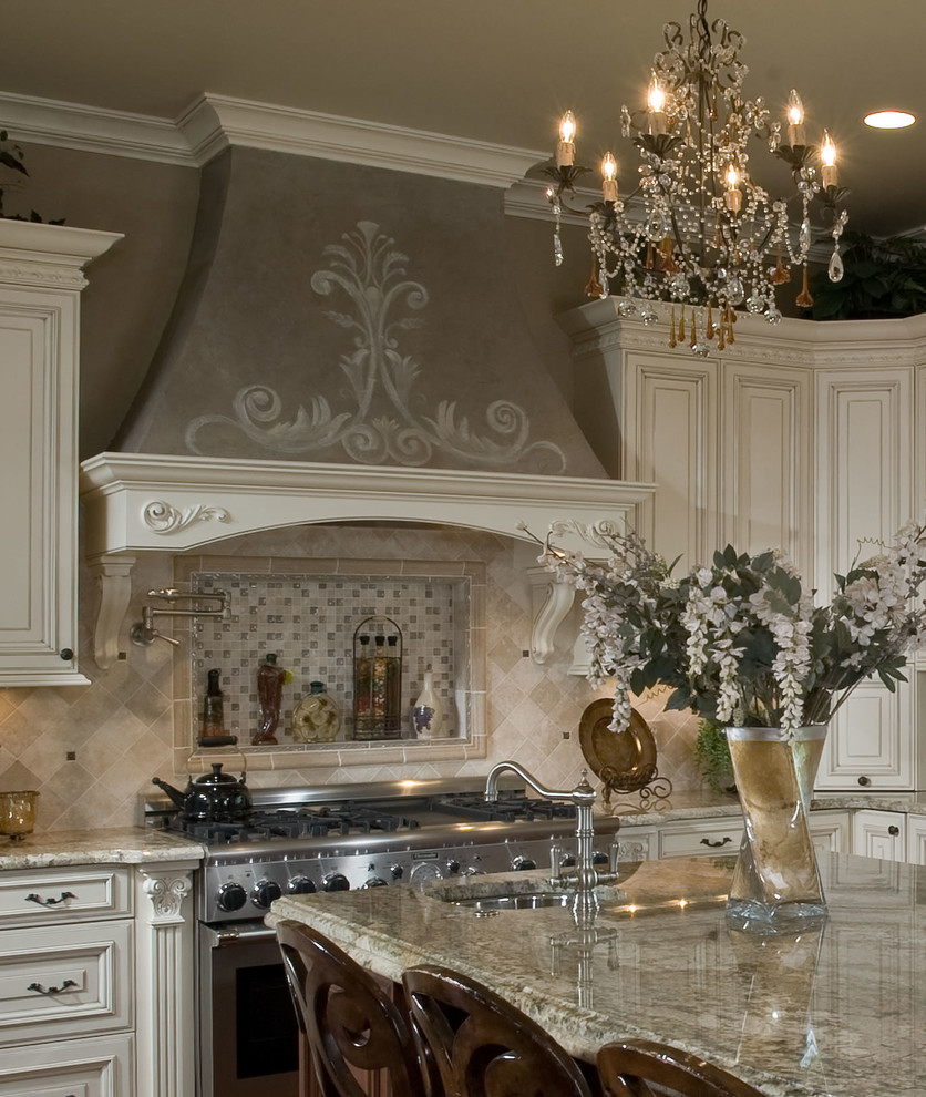 Immagine di una cucina tradizionale chiusa e di medie dimensioni con ante con bugna sagomata, lavello a doppia vasca, ante bianche, top in granito, paraspruzzi beige, paraspruzzi con piastrelle in pietra, elettrodomestici in acciaio inossidabile e pavimento in legno massello medio