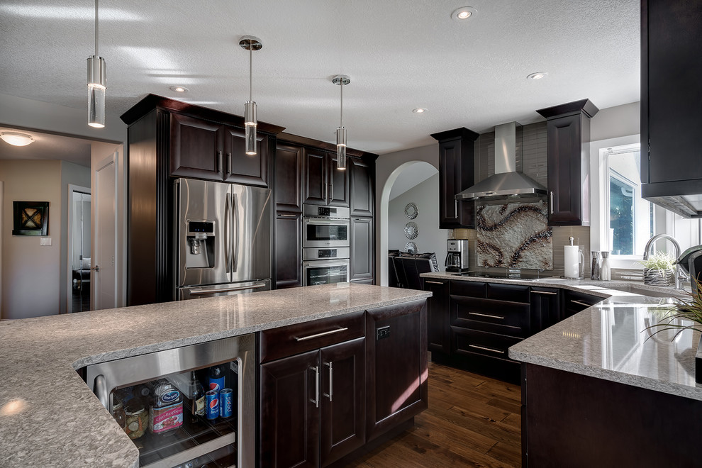 Medium sized retro u-shaped kitchen/diner in Vancouver with a submerged sink, shaker cabinets, dark wood cabinets, granite worktops, multi-coloured splashback, stainless steel appliances, medium hardwood flooring and an island.