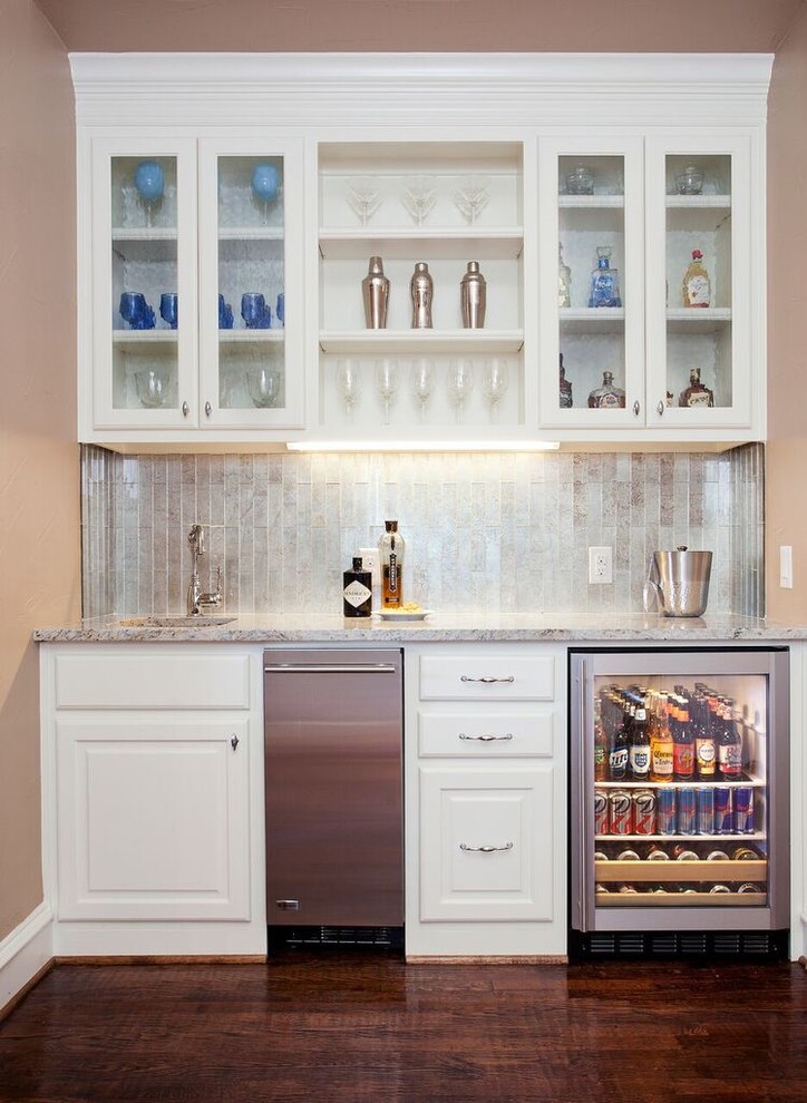 Inspiration for a small transitional single-wall dark wood floor home bar remodel in Dallas with an undermount sink, raised-panel cabinets, white cabinets, granite countertops and ceramic backsplash