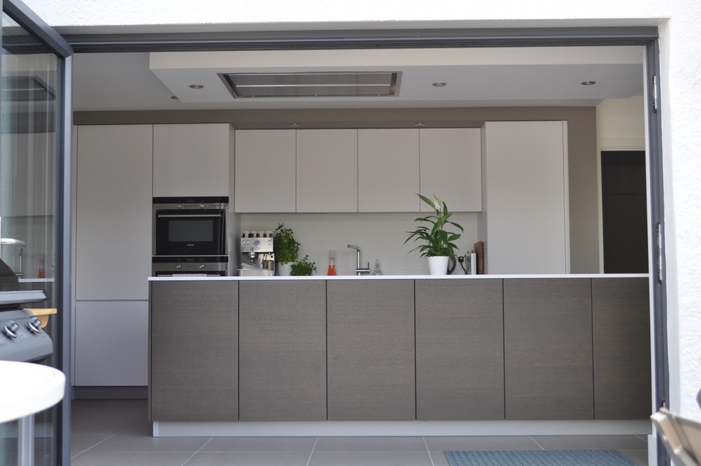 Esempio di una cucina minimal di medie dimensioni con lavello sottopiano, ante lisce, ante grigie, top in laminato e pavimento con piastrelle in ceramica