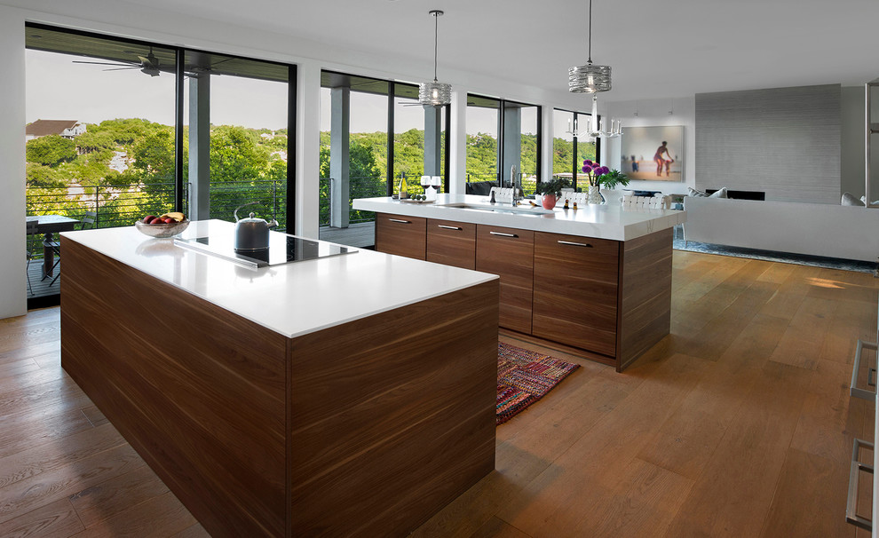 Réalisation d'une cuisine ouverte linéaire minimaliste en bois foncé de taille moyenne avec un sol en bois brun, un placard à porte plane, un plan de travail en surface solide et 2 îlots.