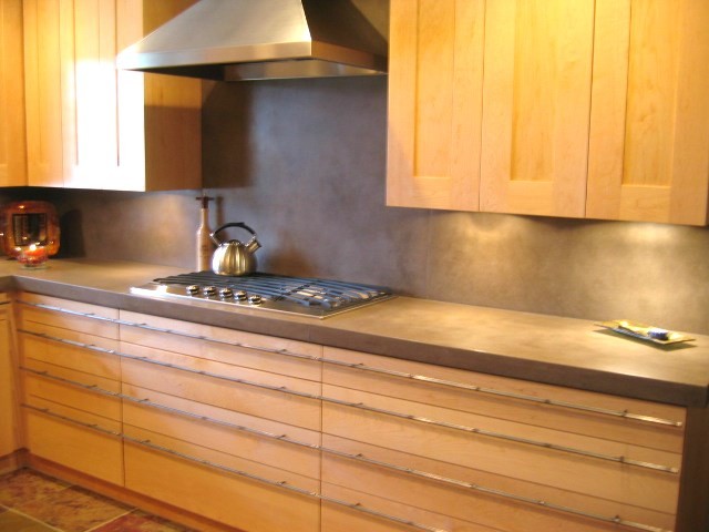 Foto på ett litet funkis kök, med en undermonterad diskho, skåp i shakerstil, skåp i mellenmörkt trä, bänkskiva i betong, grått stänkskydd, stänkskydd i cementkakel, rostfria vitvaror och skiffergolv
