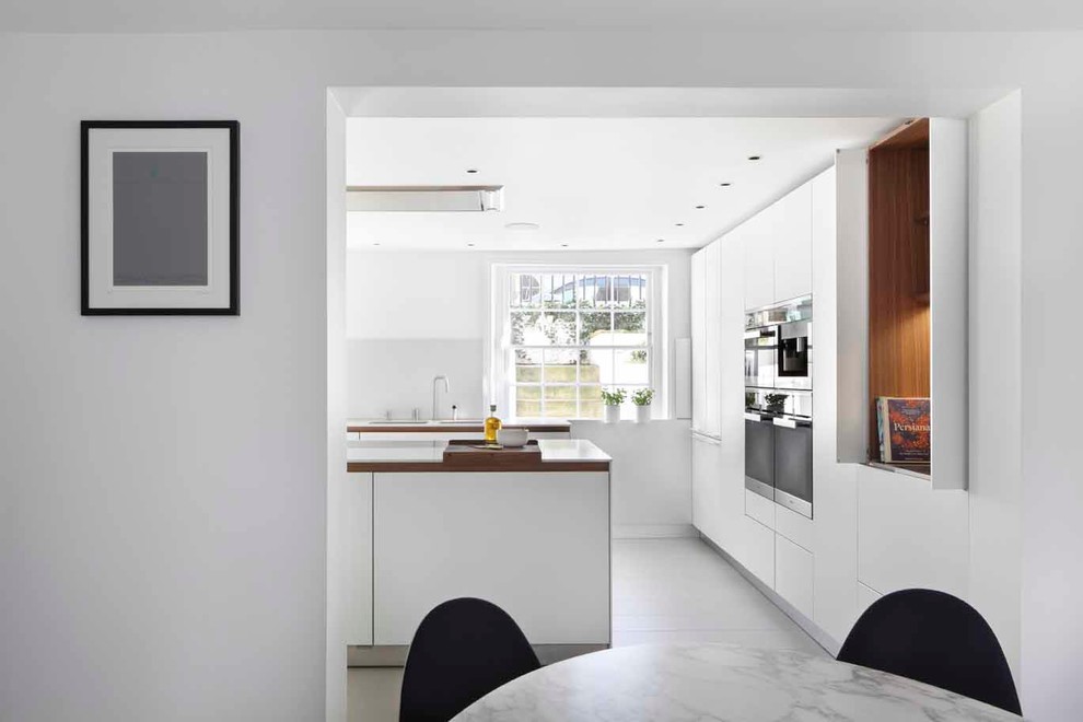 Exempel på ett mellanstort modernt kök, med vita skåp, laminatbänkskiva, svarta vitvaror, en köksö och släta luckor