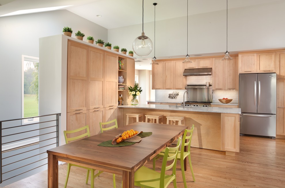 Inspiration for a contemporary galley eat-in kitchen remodel in DC Metro with marble countertops, shaker cabinets, light wood cabinets, white backsplash, subway tile backsplash and stainless steel appliances