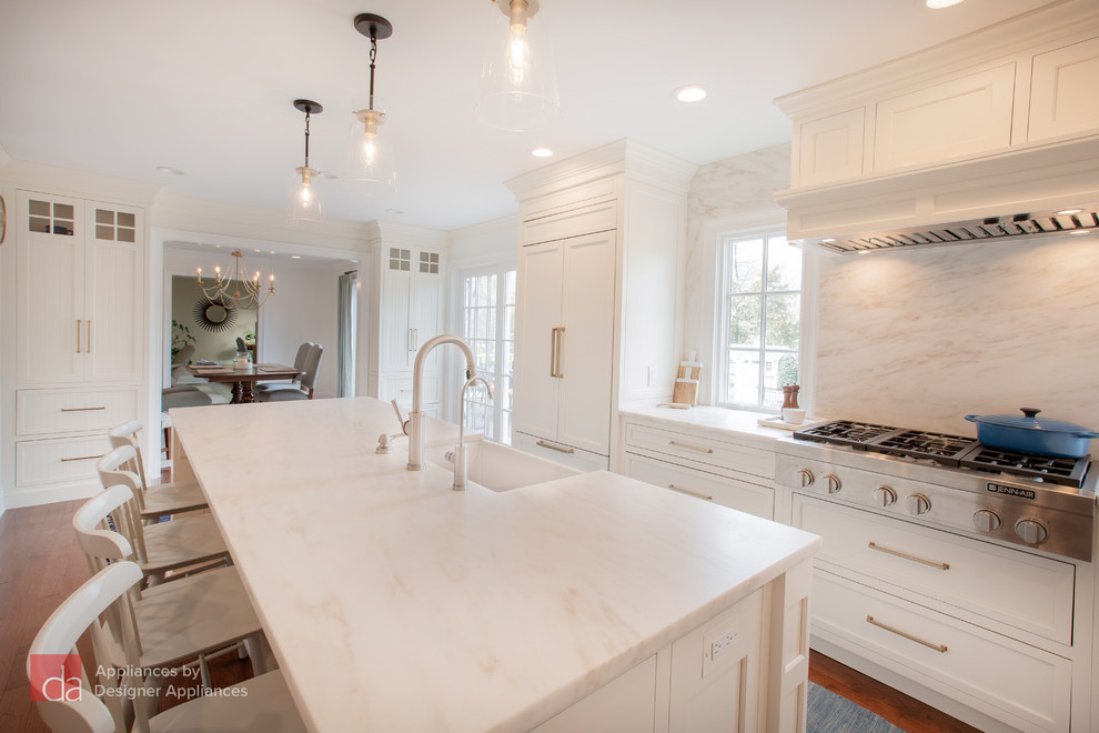 Bild på ett mellanstort vintage vit vitt kök, med en rustik diskho, luckor med infälld panel, vita skåp, marmorbänkskiva, vitt stänkskydd, stänkskydd i marmor, rostfria vitvaror, mellanmörkt trägolv, en köksö och brunt golv