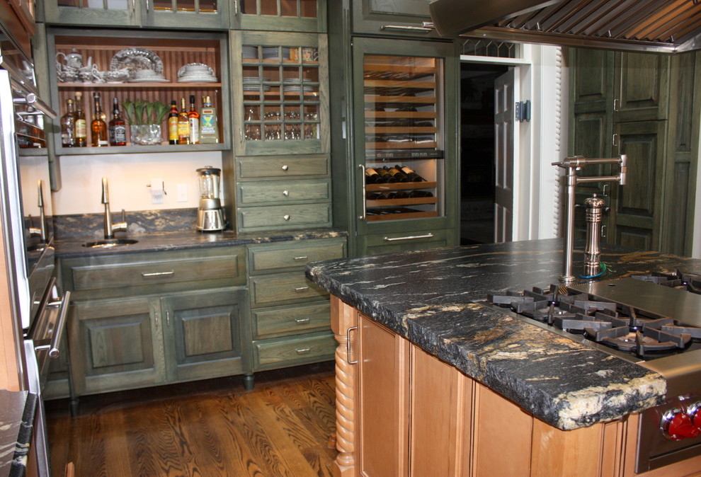 На фото: отдельная, п-образная кухня в стиле фьюжн с врезной мойкой, зелеными фасадами, гранитной столешницей и техникой из нержавеющей стали