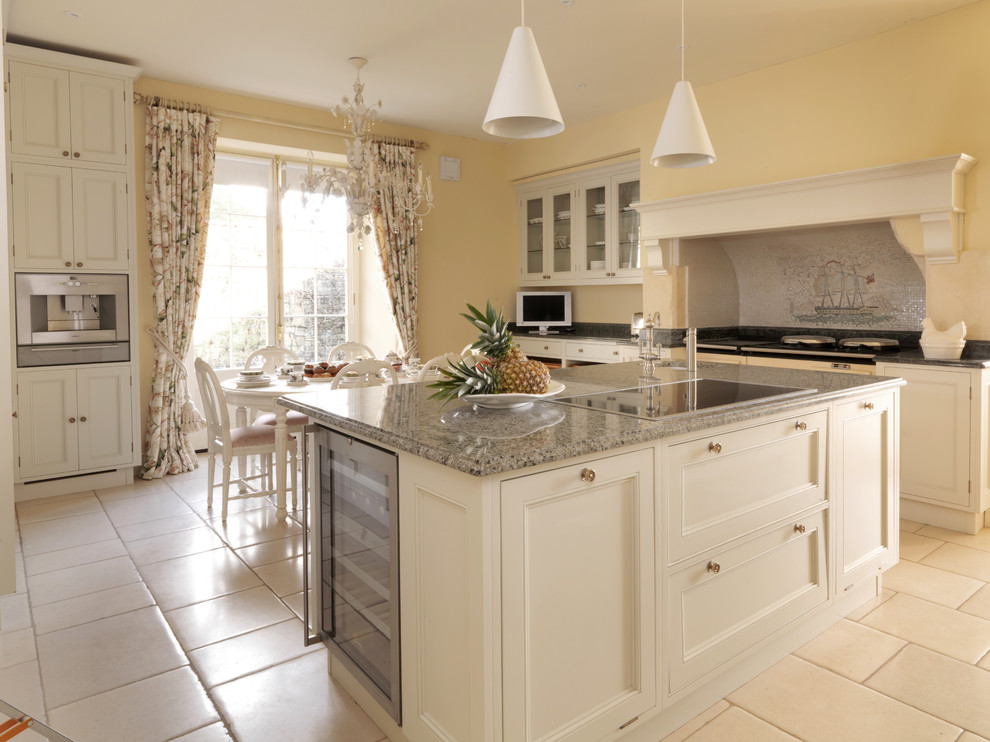 Example of a large classic galley limestone floor eat-in kitchen design in Other with a farmhouse sink, recessed-panel cabinets, white cabinets, paneled appliances and an island