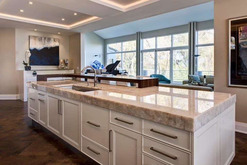 Immagine di una cucina minimal di medie dimensioni con lavello sottopiano, ante con riquadro incassato, ante bianche, top in quarzite, pavimento in legno massello medio e pavimento marrone