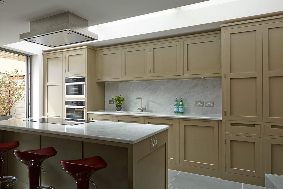 Photo of a medium sized contemporary single-wall open plan kitchen in London with an integrated sink, shaker cabinets, marble worktops, stone slab splashback, integrated appliances, slate flooring and an island.