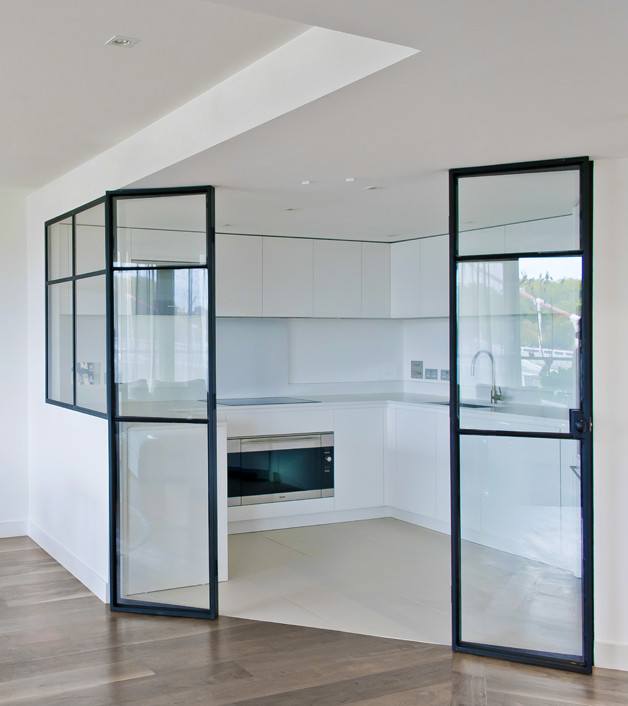 Photo of a medium sized contemporary u-shaped enclosed kitchen in London with a submerged sink, flat-panel cabinets, white cabinets, quartz worktops, white splashback, glass sheet splashback, integrated appliances, ceramic flooring and beige floors.
