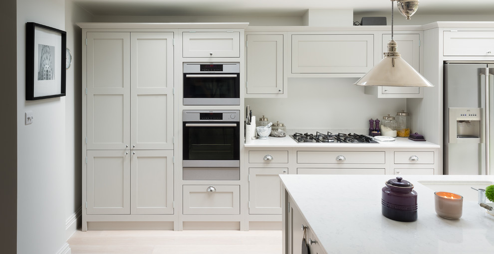Photo of a medium sized classic kitchen in London with shaker cabinets, a submerged sink, white cabinets and light hardwood flooring.