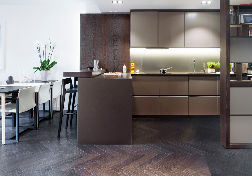 Moderne Küche in L-Form mit Waschbecken, flächenbündigen Schrankfronten, braunen Schränken, dunklem Holzboden und Halbinsel in London