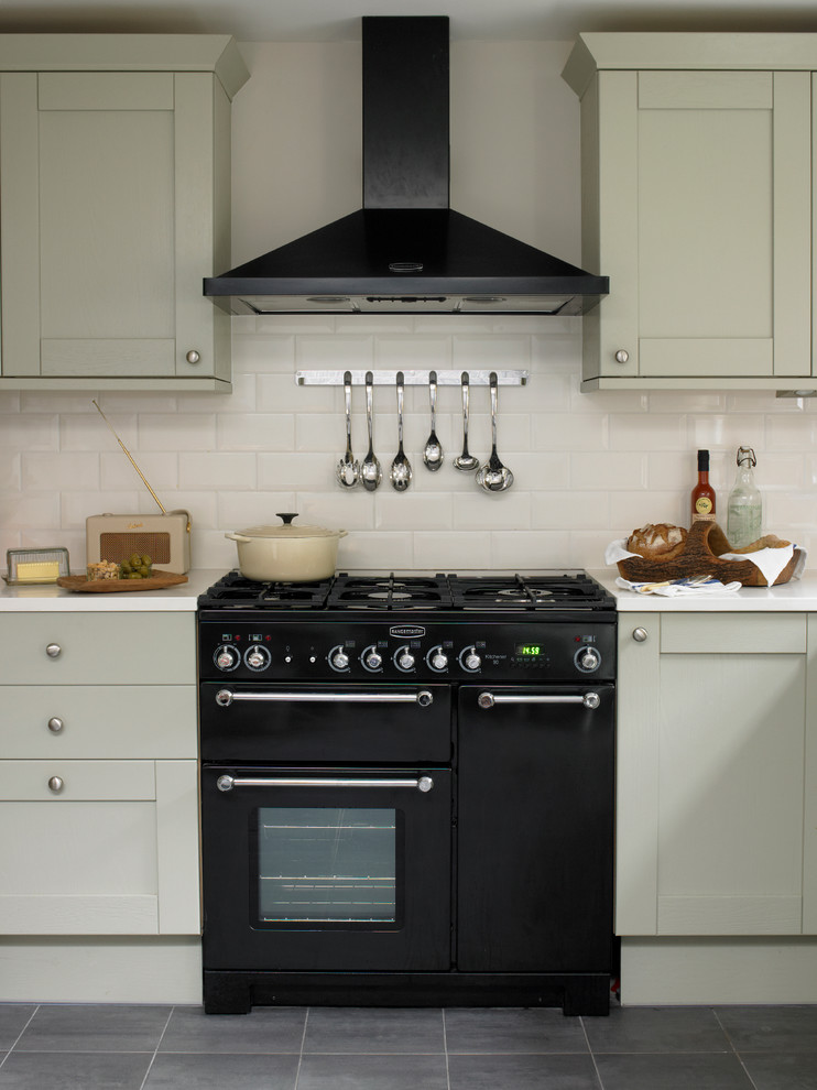 Klassische Küche mit Schrankfronten im Shaker-Stil, grauen Schränken, Rückwand aus Metrofliesen und schwarzen Elektrogeräten in London