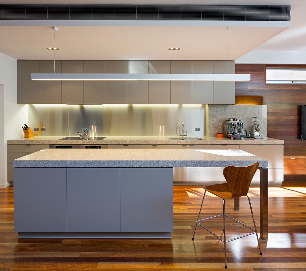 Offene, Einzeilige Moderne Küche mit Unterbauwaschbecken, flächenbündigen Schrankfronten, beigen Schränken, Küchenrückwand in Metallic, Küchengeräten aus Edelstahl, braunem Holzboden und Kücheninsel in Brisbane
