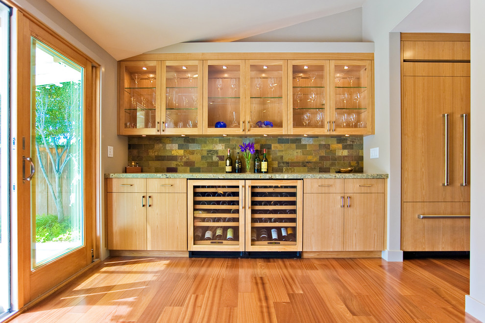 Exempel på ett mellanstort modernt grön grönt kök, med luckor med glaspanel, skåp i mellenmörkt trä, mellanmörkt trägolv, stänkskydd i skiffer, granitbänkskiva, grönt stänkskydd, integrerade vitvaror och brunt golv