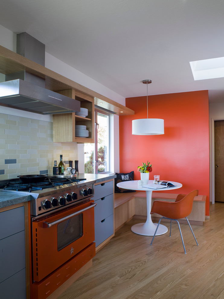 Diseño de cocina contemporánea con armarios abiertos, salpicadero multicolor y electrodomésticos de colores